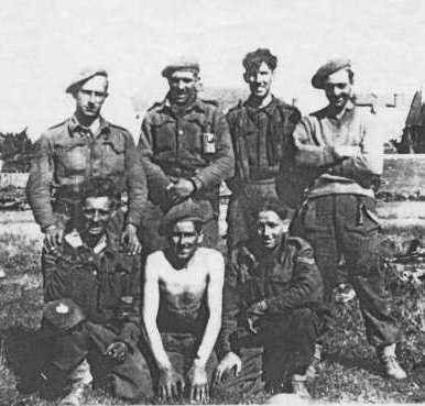 Group photograph of members of No 8 Platoon, taken on 12 September 1944 after the capture of Le Havre. Left to right: Back Row – Private Deal, Private Patrick, Private Gordon Duffin, Private Button; Front Row – Private Harris, Sergeant Sweeny, Corporal Millington. Thirty-five men of the platoon had landed on D-Day and only these seven were still on active service by 12 September. Of the seven, only two were still on active service by VE-Day.